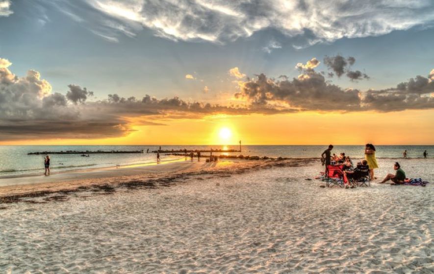 Florida beach sunset with families enjoying Gulf Coast for Florida mortgage broker services